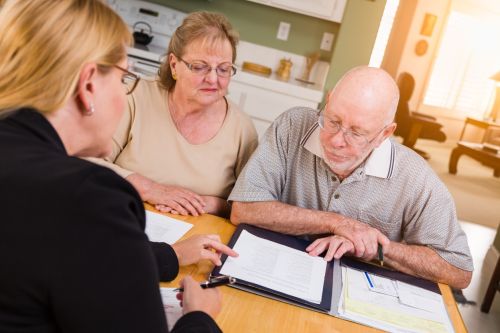 Senior Adult Couple Going Over Documents in Their Home with Agent At Signing. Planning for Incapacity in Ohio: Senior Adult Couple Going Over Documents in Their Home with Agent At Signing. Planning for Incapacity in Ohio: What Happens When You Can’t Make Decisions? concept