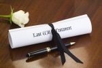 A scroll of a Last Will & Testament, tied with a black ribbon on a mahogany desk, with a white rose and pen. What Happens if You Die Without a Will in Ohio? concept.